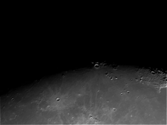A crater peeking out from beyond the terminator.